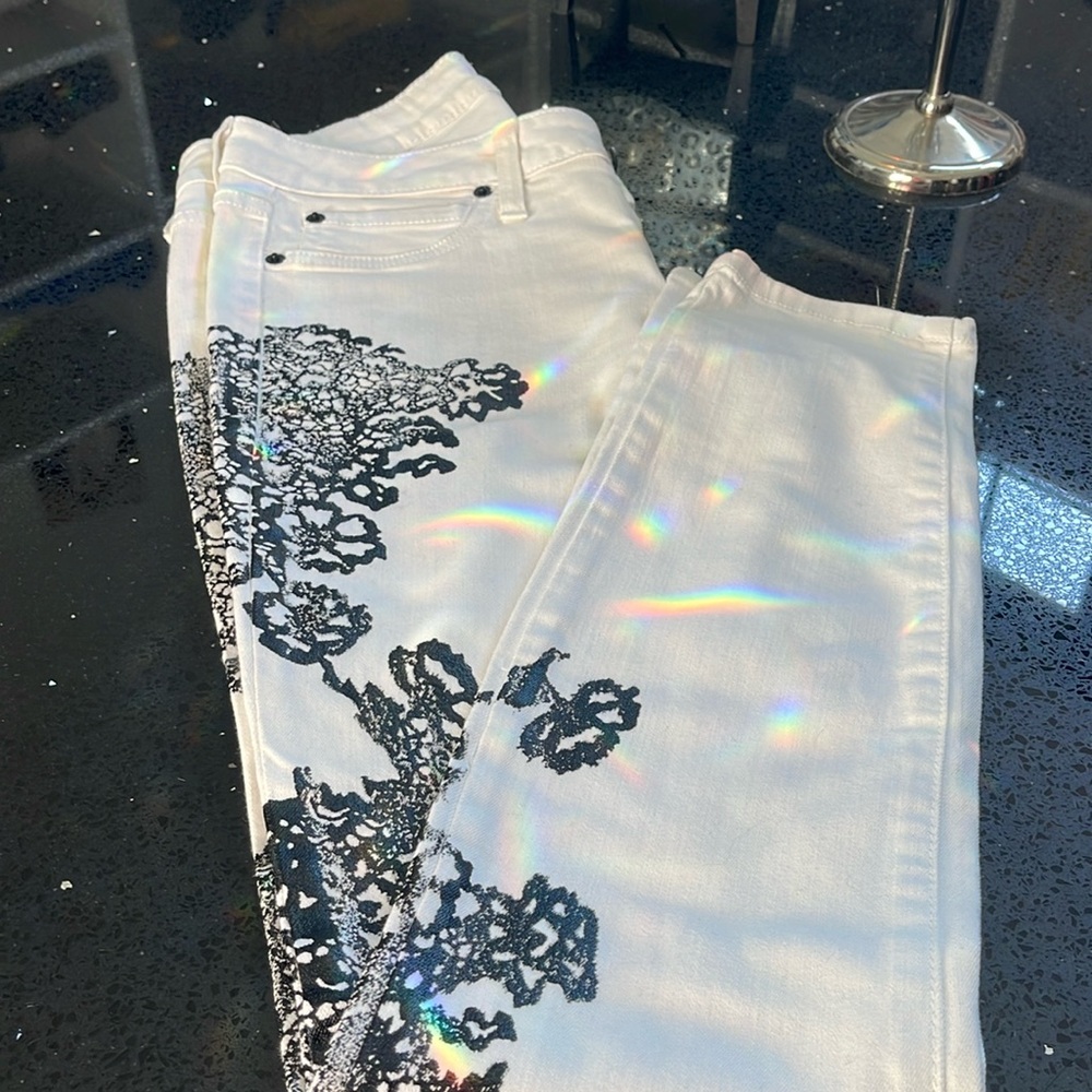 Bebe women’s white Jeans with black lace stenciling down the legs